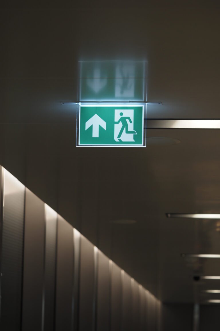 Green exit sign points towards safety in a hallway